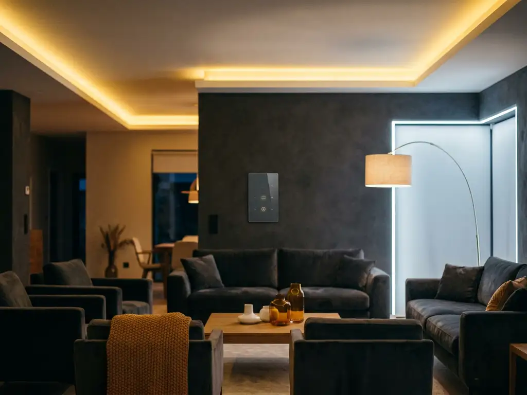 Moderne woonkamer met slimme dimmer, gouden LED-strips in plafondnissen en designvloerlamp tegen antraciet muren.